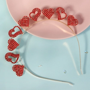 Détails d'un serre-tête doré orné de cœurs en strass rouges étincelants pour femmes