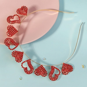 Détail d'un serre-tête en métal doré orné de cœurs en strass rouges pour les fêtes