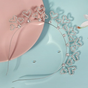 Détail du serre-tête cœur argenté orné de strass en cristal sur plateau rose