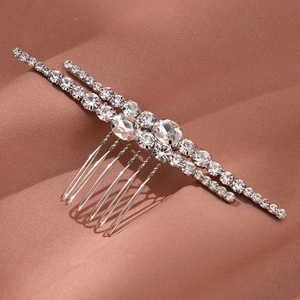 Detailed close-up of a silver bridal hair comb with rows of rhinestones and crystal accents