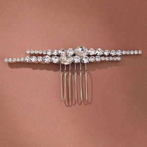 Close-up of silver hair comb with double-row sparkling rhinestones and metal teeth