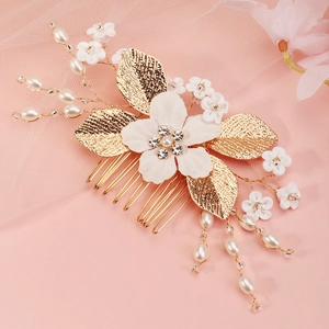 Detail of bridal hair comb with handmade fabric flowers, pearls and golden leaves