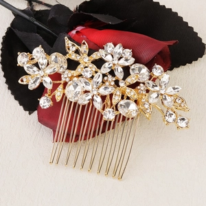 Détail d'un peigne de mariée avec base en alliage doré et strass brillants sur fleurs