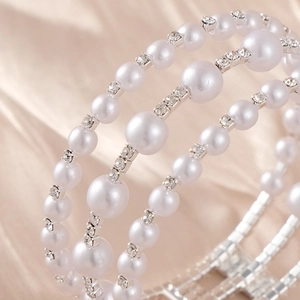 Detailed macro shot of triple-layer pearl bracelet with sparkling rhinestone spacers