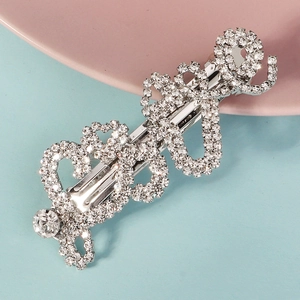 Détail d'une barrette à cheveux argentée avec strass brillants et design élégant
