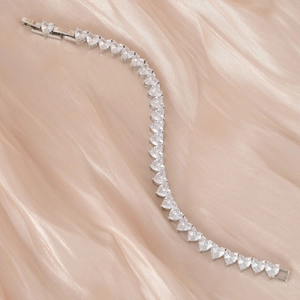 Élégant bracelet tennis coeur en argent avec zircons sur fond de satin couleur champagne