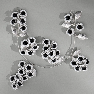 Detailed view of handmade dark style bridal headband with metal leaves and white flowers