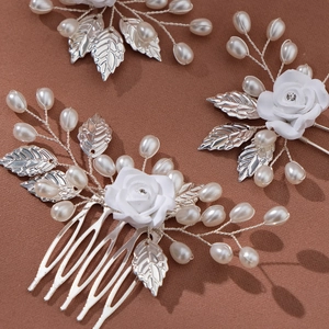Detailaufnahme des Braut-Sets mit weißen Keramikrosen und silbernen Metallblättern