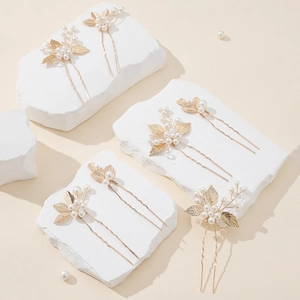 Detail of 6-piece gold leaf hair pins with white pearls for bridal wedding hairstyles