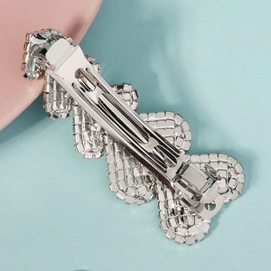 Détail de la barrette à cheveux argentée en strass montrant le fermoir crocodile en métal