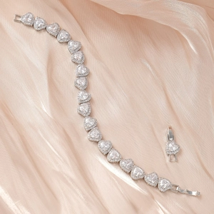 Gros plan du bracelet en zircon en forme de cœur avec serti griffe argenté sur satin