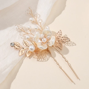 Dettaglio del fermaglio per capelli a fiore dorato vintage con perle e foglie