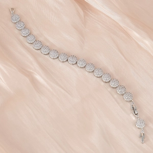 Élégant bracelet tennis en argent avec zircons sur fond de soie de couleur champagne