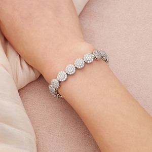 Gros plan du bracelet en argent avec maillons circulaires sertis de zircons sur un poignet