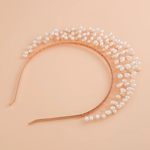 Détail macro d'un serre-tête de mariée fait main avec perles blanches et feuilles dorées