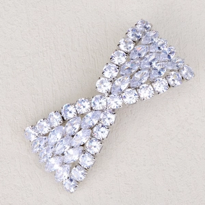 Macro detail of silver-tone metal hair clip with sparkling cubic zirconia in bow design