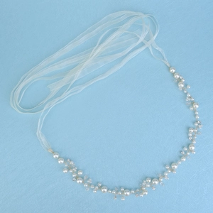Detail of bridal sash with hand-woven pearls, crystals, and long white organza ribbons