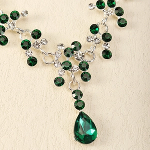 Détail macro du collier de mariée avec cristaux vert émeraude en goutte et strass brillants