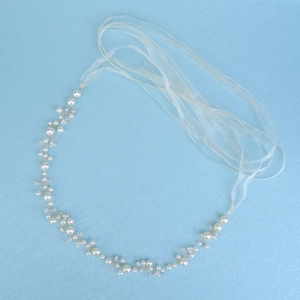 Close-up of bridal sash with white pearls, crystals, and gold wire floral weaving