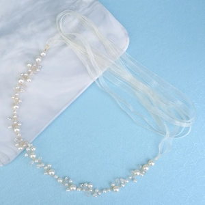 Elegant bridal hair band with white pearls and sparkling crystals on golden wire