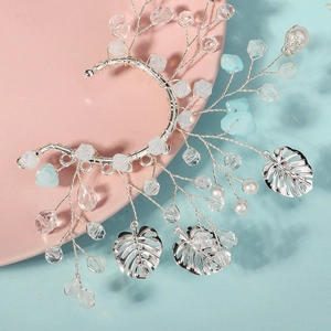 Détail de manchette d'oreille argentée avec cristaux bleus, perles et feuilles monstera