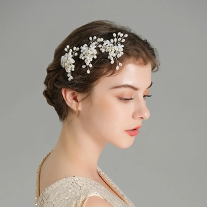Close-up of handmade bridal hair pin with white pearls and sparkling crystals