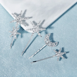 Detail of silver star and moon hair clip set with sparkling rhinestones on blue surface