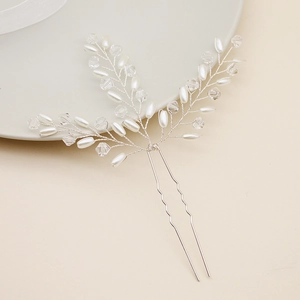 Detailed macro view of handmade bridal hair pin with pearls and leaf-shaped crystals