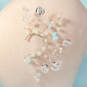 Détail de manchette d'oreille elfe avec feuilles, cristaux bleus et perles blanches