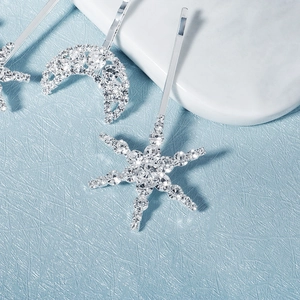 Detailed macro view of silver star and moon hairpins with sparkling crystal rhinestones
