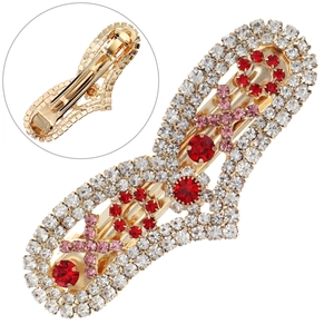 Vue détaillée de la pince dorée et des motifs complexes de cœurs en strass rouges