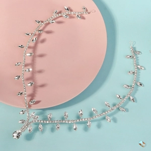 Détail de la vigne de cheveux de mariée argentée avec strass marquise sur fond pastel
