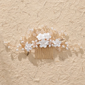 Detail of handcrafted bridal hair comb with white resin flowers and pearl accents