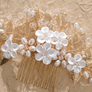 Detail of bridal hair comb with handmade clay flowers, pearls, and golden leaves