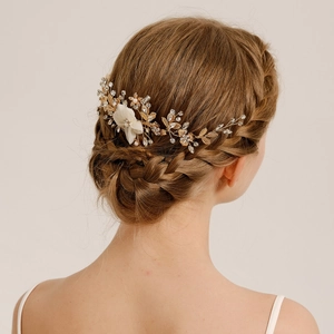 Detailed view of handmade bridal hair comb with cream fabric flowers and pearls