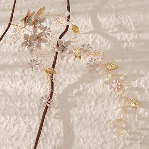 Detailed close-up of bridal headband with golden leaves, pearls and crystal flowers