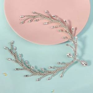 Close-up of silver vine bridal headpiece with sparkling crystals on pink tray