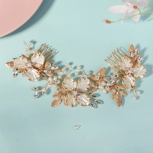 Détail macro du peigne de mariée doré avec fleurs en coquillage et perles