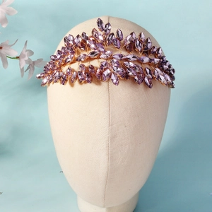 Detailed close-up of purple crystal crown bridal headpiece on a beige mannequin