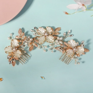Détail d'un peigne à cheveux mariée doré avec pétales en coquillage, perles et cristaux