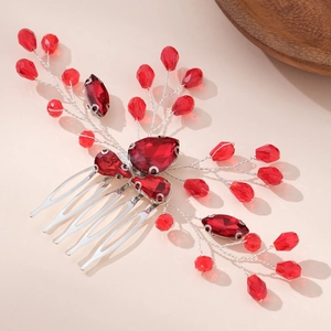 Handmade bridal hair comb with red crystals and silver wires on beige background