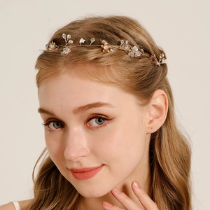 Detail eines Braut-Stirnbands mit goldenen Blumen und Kristallperlen an einem Model