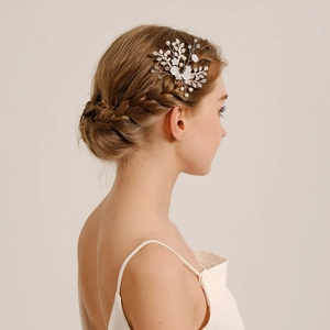 Detailed view of handmade bridal hair pin with white flowers and pearls on a model