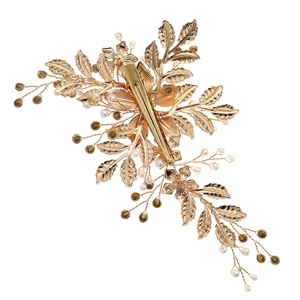 Detailed view of luxury gold floral hair clip with crystal leaves and artificial pearls