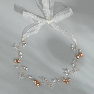 Detail eines handgefertigten Braut-Haarbands mit Strass, Perlen und Organzaband