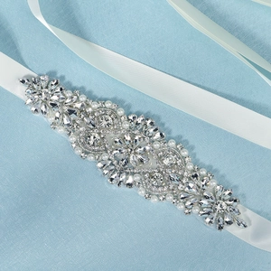Detail of luxury bridal belt with sparkling silver rhinestones and pearls on white ribbon
