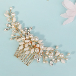 Détail du peigne de mariée avec perles, cristaux et fil d'or sur fond bleu clair
