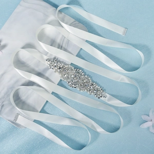 Macro shot of bridal sash with luxury rhinestones and pearls on white satin ribbon