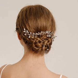 Detailed view of silver crystal bridal hair comb styled on a bride's woven bun hairstyle