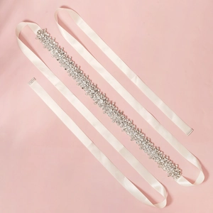 Dettaglio di cintura da sposa con fiori di cristallo su elegante nastro di raso bianco